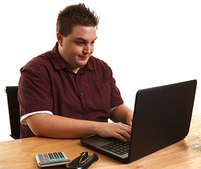 A person sitting at a desk in front of a laptop.