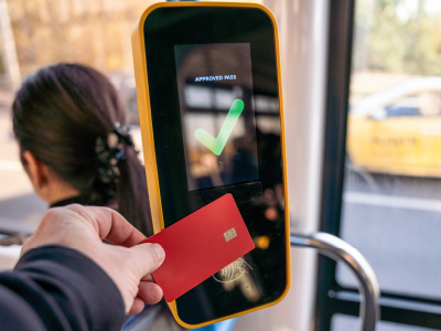 contactless payment machine with red bank card on bus