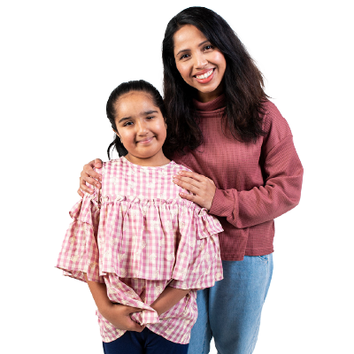 Mother embracing child with arms on her shoulder both smiling