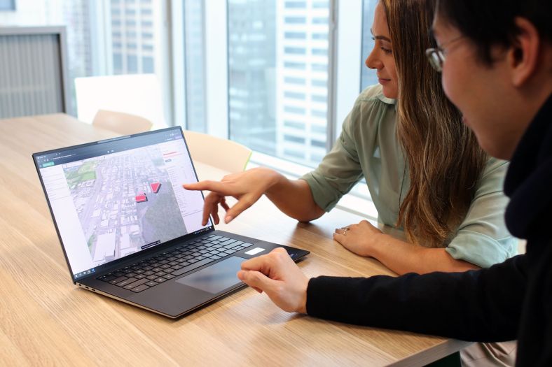 Man and woman using the Land iQ online tool on a laptop.