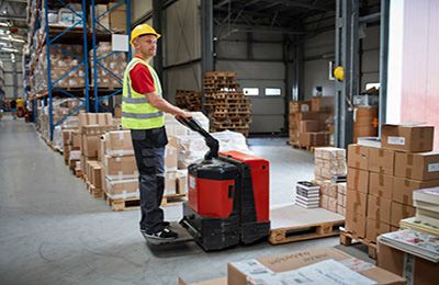 Worker using a pallet forklift.