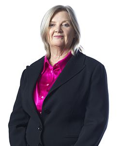 Tess Herbert looking directly at the camera wearing a magenta blouse and black jacket