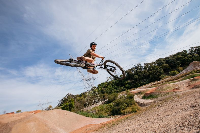 Mountain biker doing a jump at Bare Creek bike park.