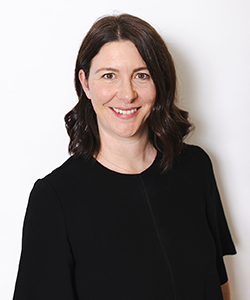 Smiling dark haired woman wearing a black top