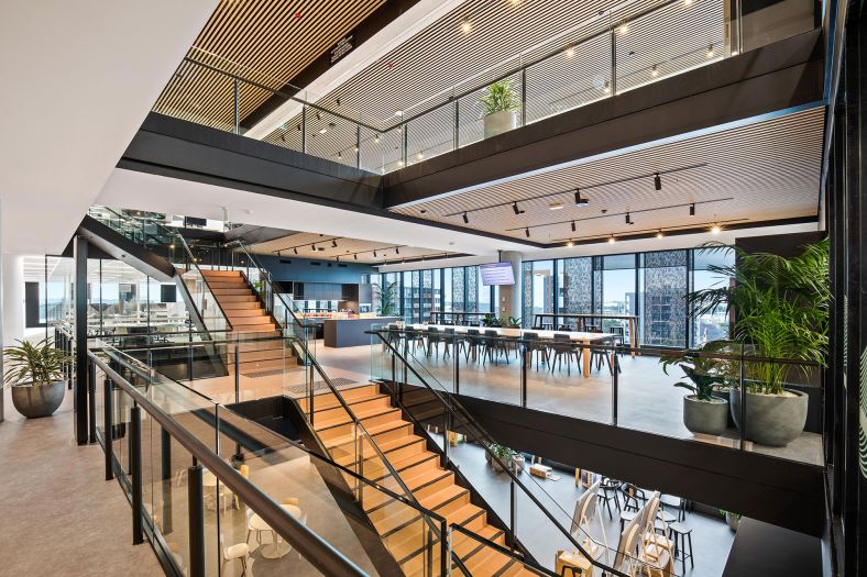 Inside 3 levels of office floors including chairs, tables, pot plants and stairways.