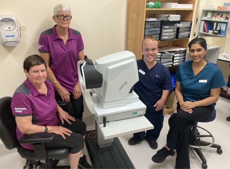 Two Kiosk Auxiliary members with two Broken Hill Hospital Specialist Clinic staff members and an eye machine purchased using part of the Kiosk donation.