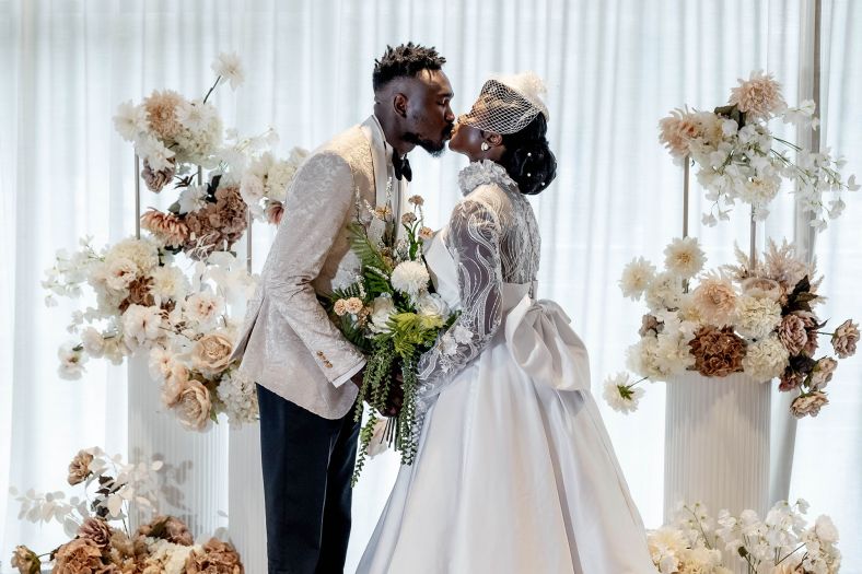 A bride and groom share a kiss at the altar