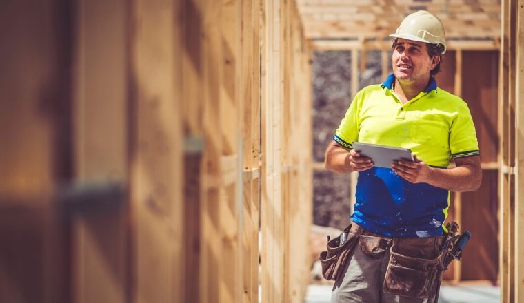 A builder on a construction site wearing a white helmet