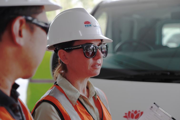 Two people in hard hats talking to each other