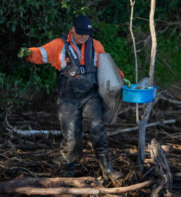 man picking up debris after floods