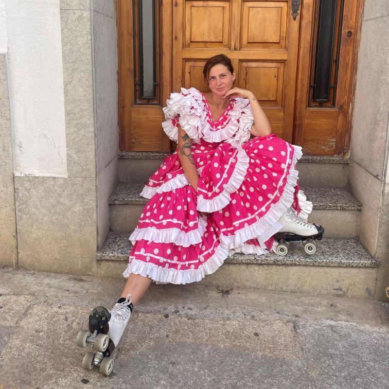 Woman in roller-skates posing on stairs.