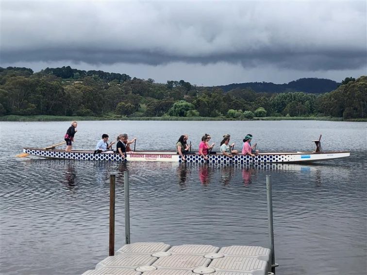 Group of women in Dragonboat on lake.