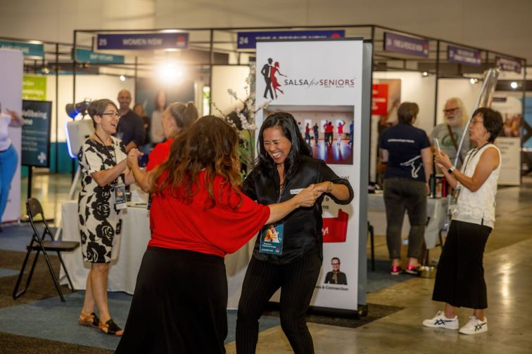 two women holding hands dancing at Expo