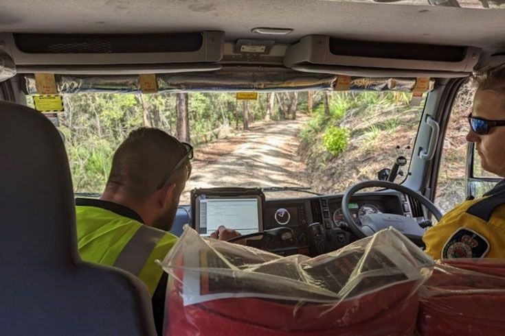 Two firefighters from the RFS sitting in the front of a truck