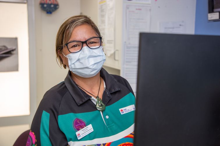 Endorsed enrolled nurse wearing Aboriginal uniform smiling