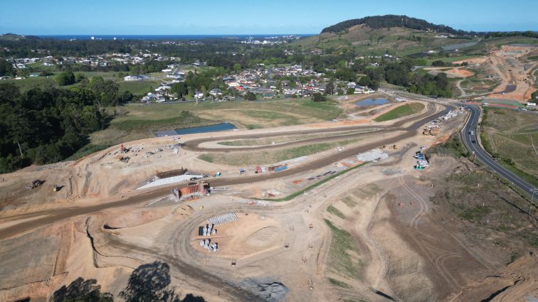 Aerial view of a construction site featuring a road and houses.