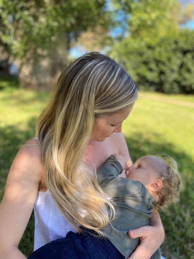 Mother breastfeeding her baby in a park