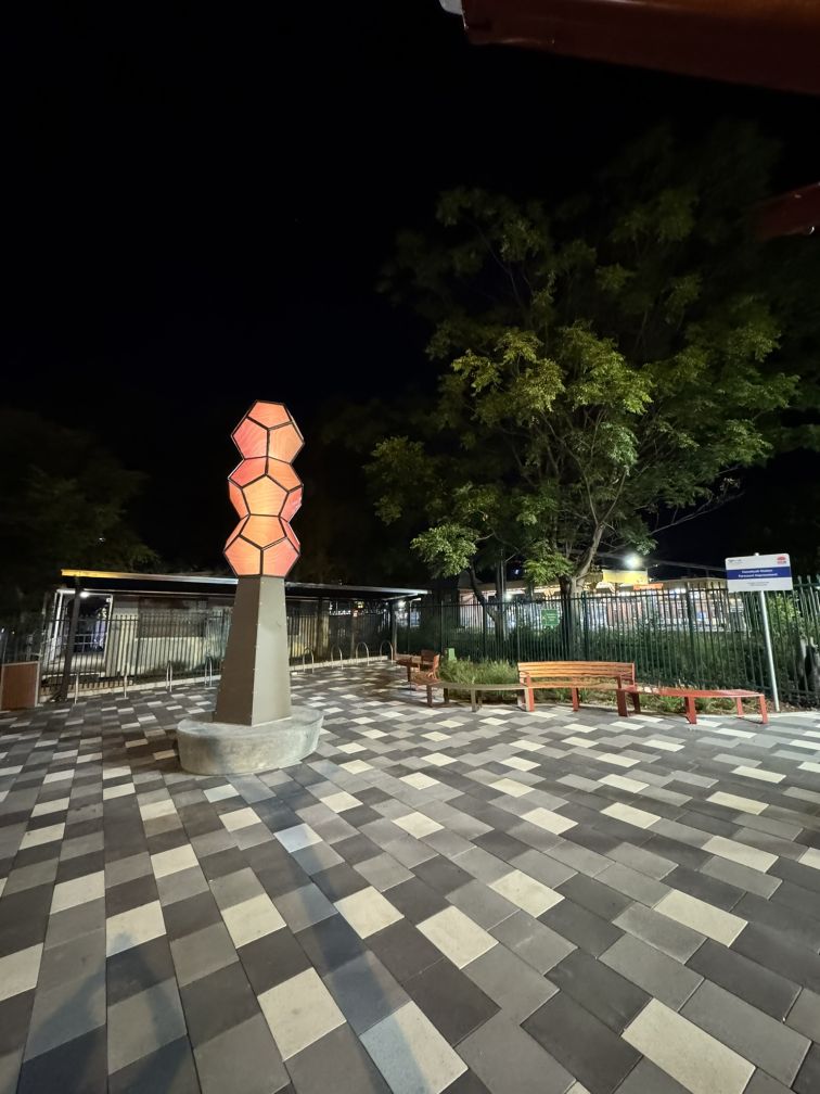 a sculpture lit up after dark at Homebush Station