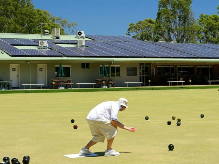 Person bowling on green at North Beach Bowling Club