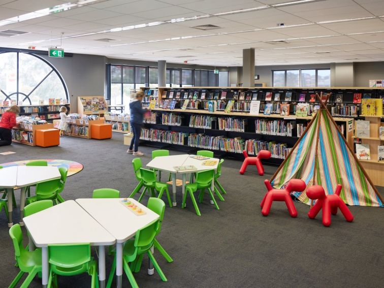 Kids tables and chairs and a playtent in the kids zone.