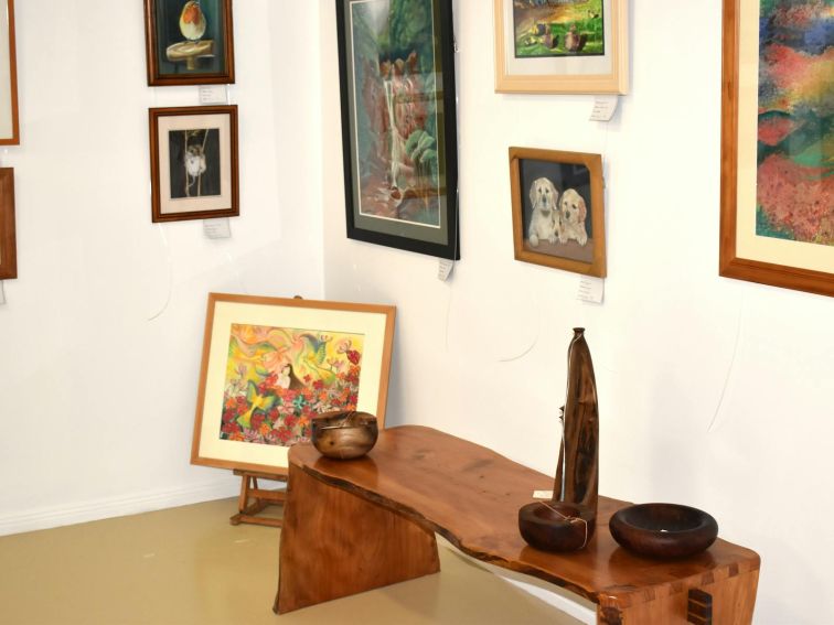 Corner of room with artwork on walls and bench.