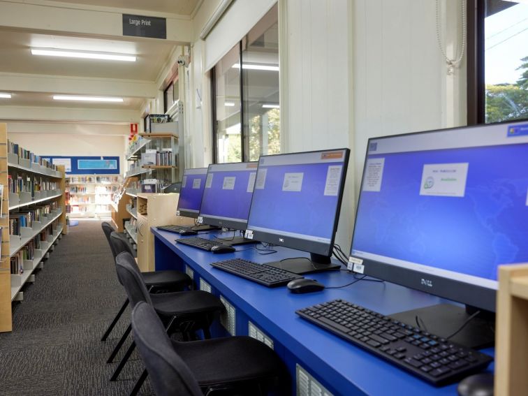 Four computers and chairs for use by visitors.