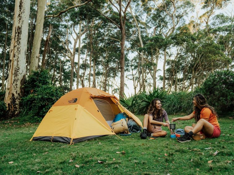 Two people sitting beside a tent at Depot Beach Campground