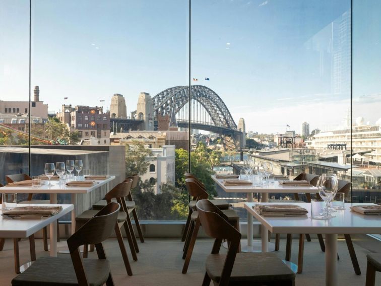 A restaurant interior overlooking the Sydney Harbour Bridge.