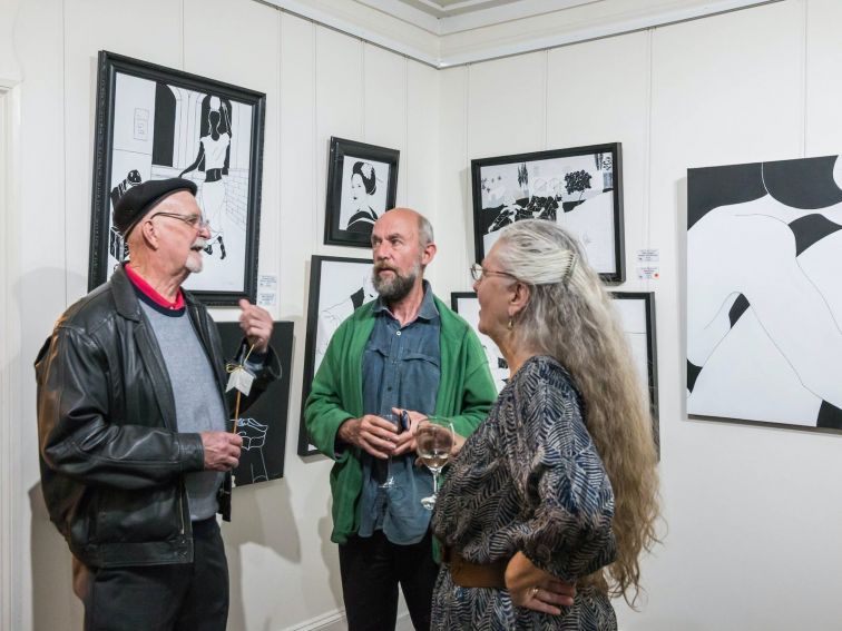 artist and friends standing with art work on the walls