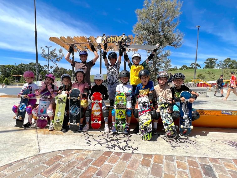 A group of young students pose for a photo after their group lesson.