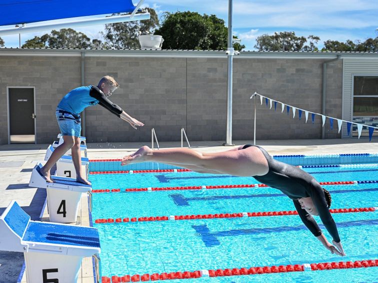 50m pool children diving from blocks