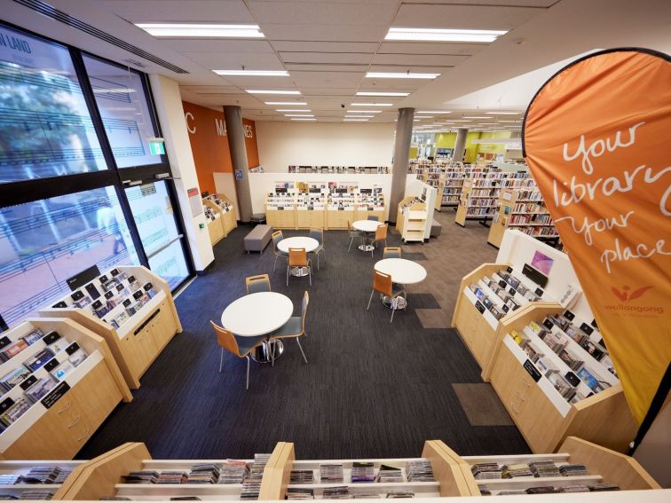 A view of tables, chairs and resources in the library.