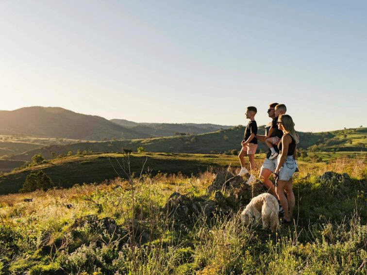 A family stands ontop of a hill overlooking the Bridle Track