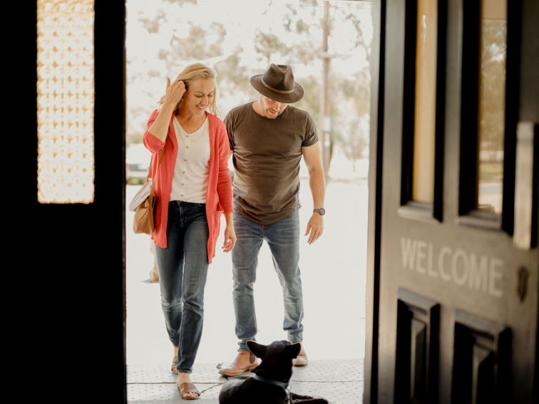 dog sittingth edoorway to the Balldale Hotel reating a middle aged couple walking in to the pub