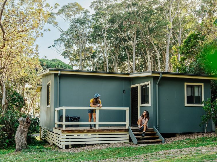 Two people outside a cabin at Depot Beach.