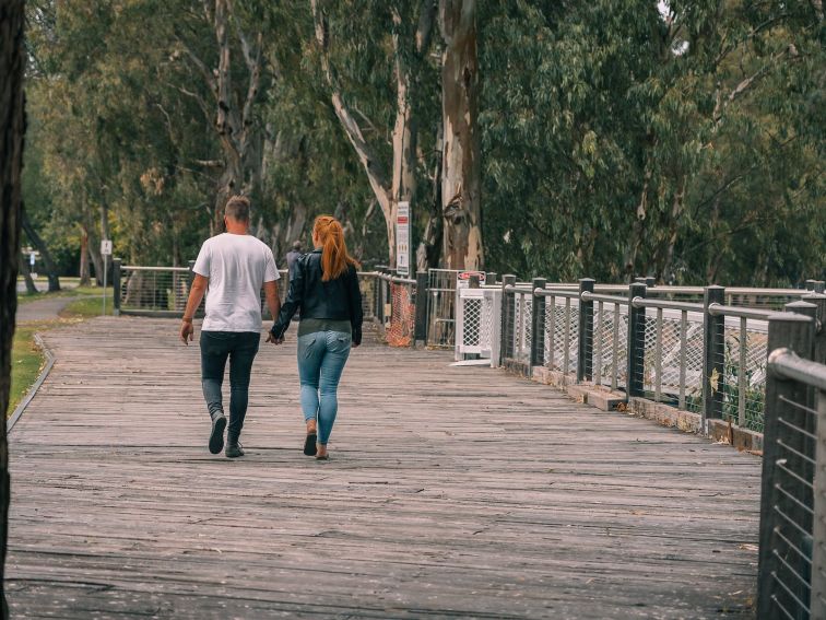 Couple walking on wooden boardwalk