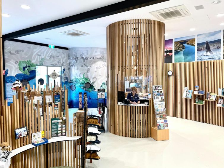 Reception desk in the middle of the room with wooden slats on the walls as decoration.