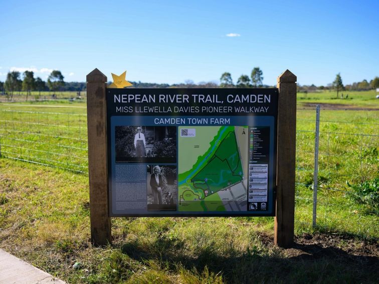 Sign on a pathway with grass field in background