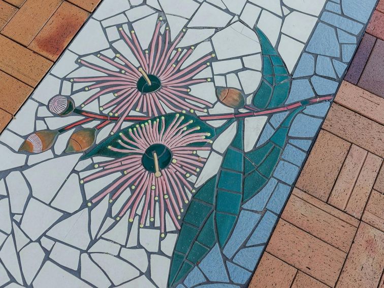 tile mosaic of gumnut branch with 2 flowering, 2 partially flowering gumnuts and 2 closed gumnuts