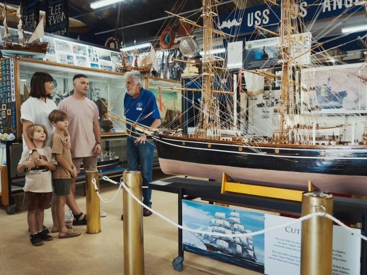 A volunteer giving a young family information about the museum