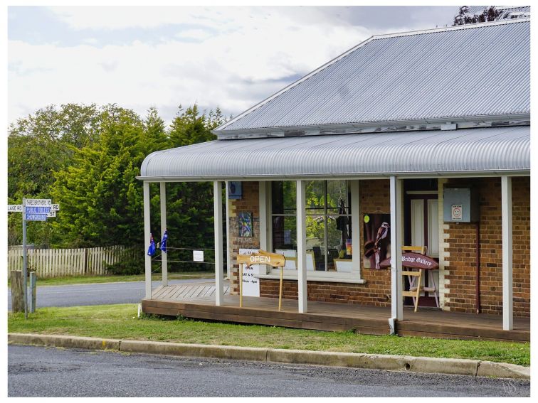 An old building with bullnose verandah stands on the corner of two streets; a grass verge in front