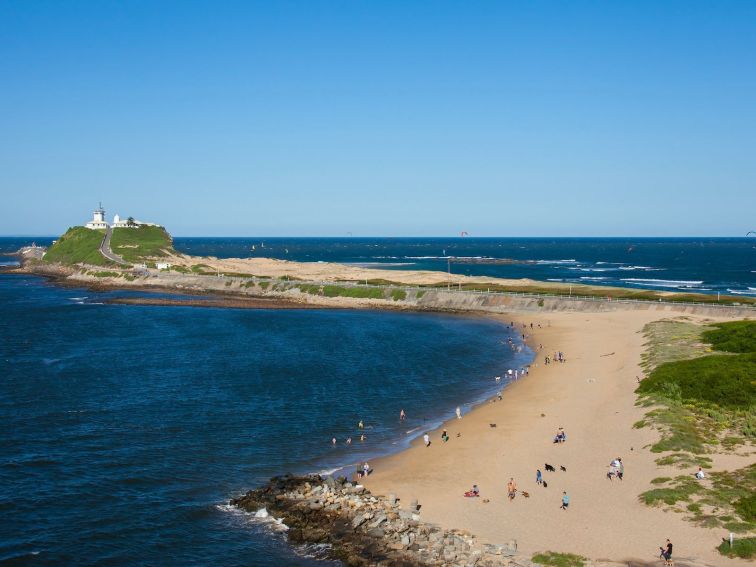 People enjoying Horseshoe Beach with views towards Nobby's Lighthouse, Newcastle