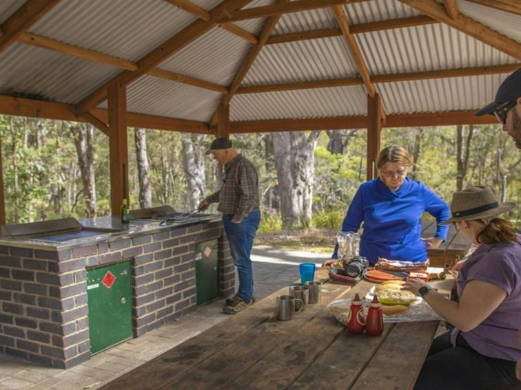 A group of people having a picnic under the shelter at Boonoo Boonoo Falls picnic area in Boonoo