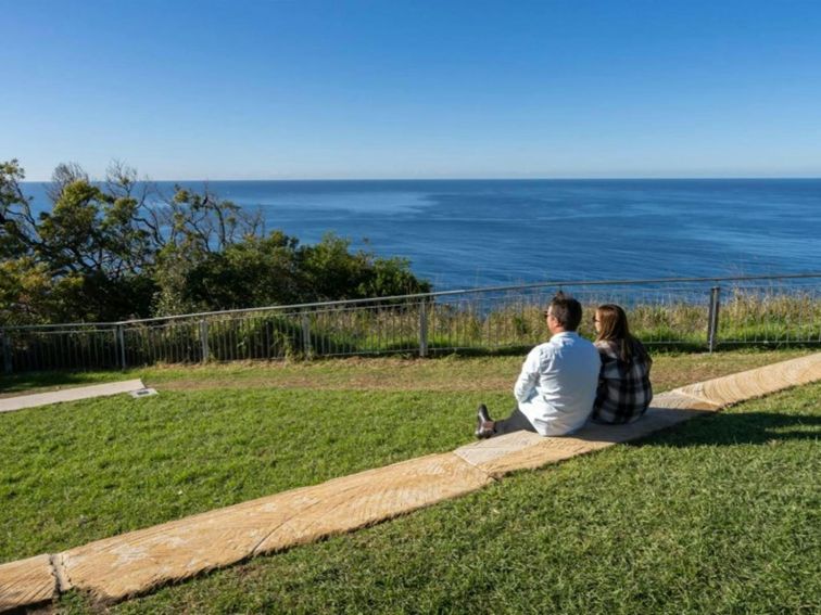 A couple enjoying the view at Crackneck Point lookout in Wyrrabalong National Park. Photo: John