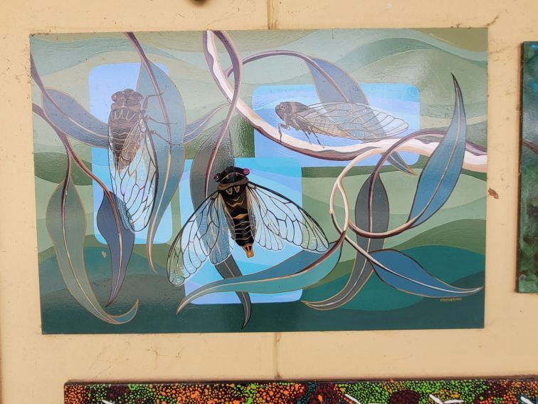 Blue and green paining of cicadias hiding on the gum tree leaves