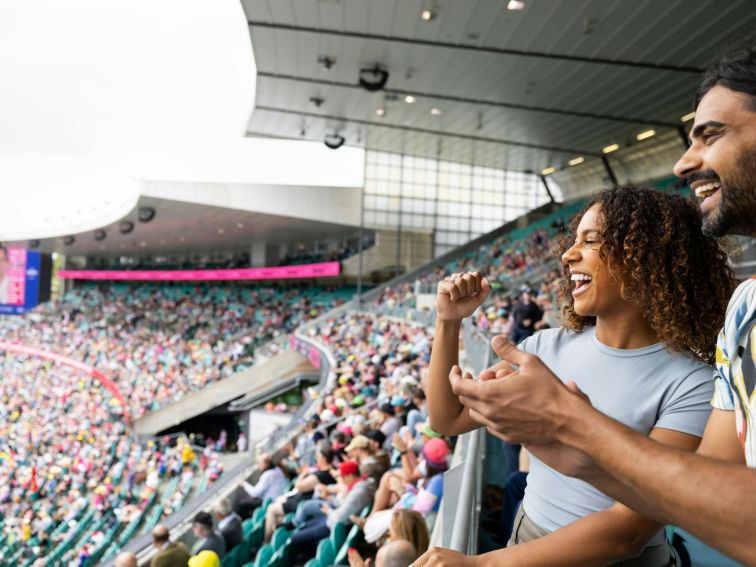 Friends cheering and enjoying a cricket game at the Sydney Cricket Ground