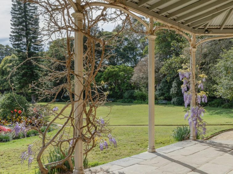 Exterior of historic house with wisteria growing up pillars