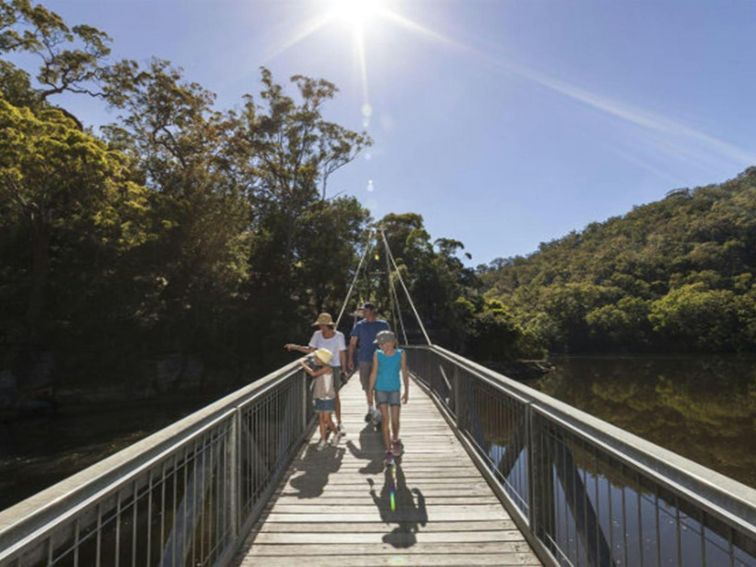 Family walking along Gibberagong walking track at Bobbin Head in Kur-ring-gai Chase National Park.