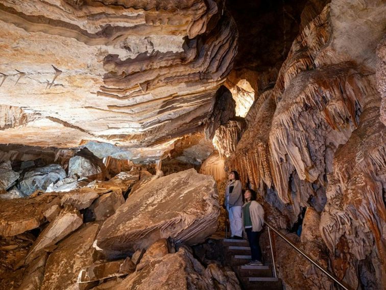 Two visitors exploring the caves at Jenolan. Photo: Jenolan Caves &copy; DPE