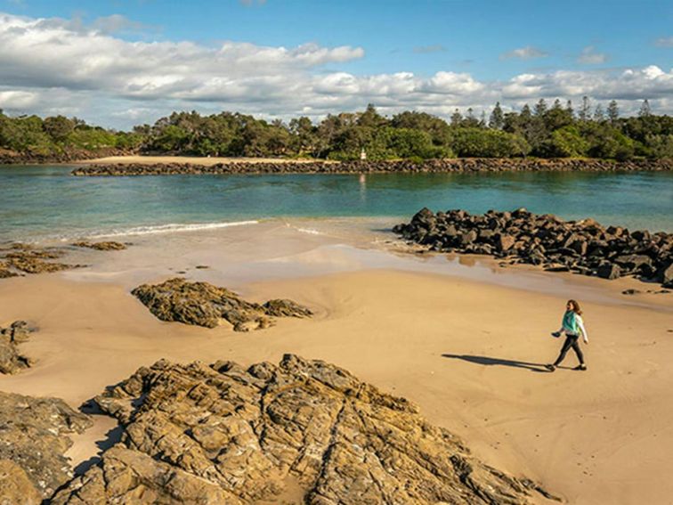 Woman walking along the beach at North Head walking track in Brunswick Heads Nature Reserve. Photo: